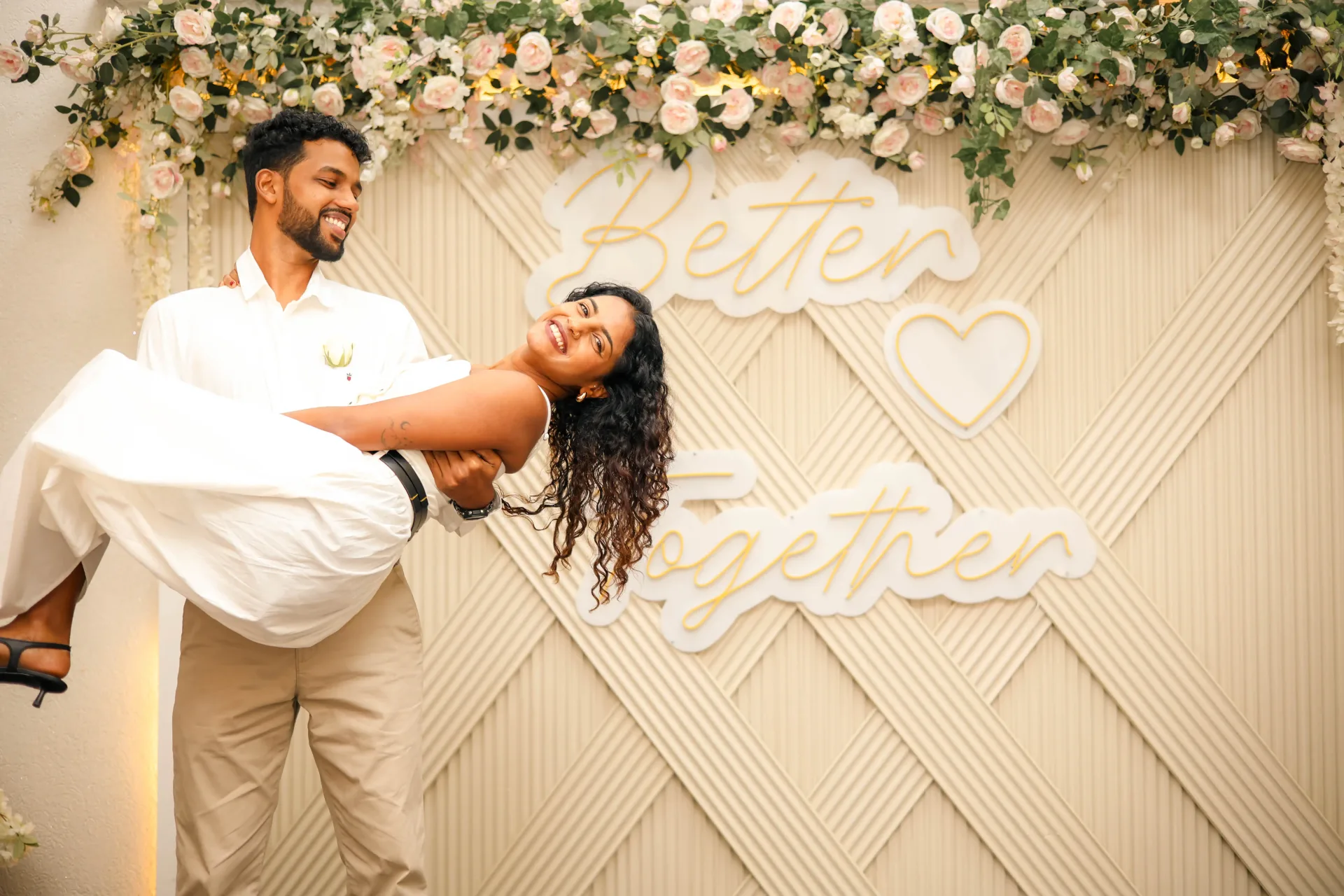 Ashley carrying Khush in front of a fun backdrop